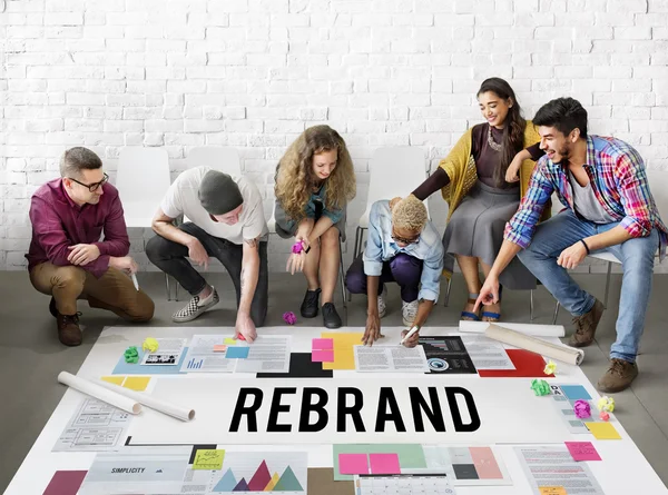 Rebranding en 2025 : guide complet pour réinventer votre marque 1 Une équipe collabore sur un projet de rebranding, examinant les éléments de design et les palettes de couleurs disposés sur une table.